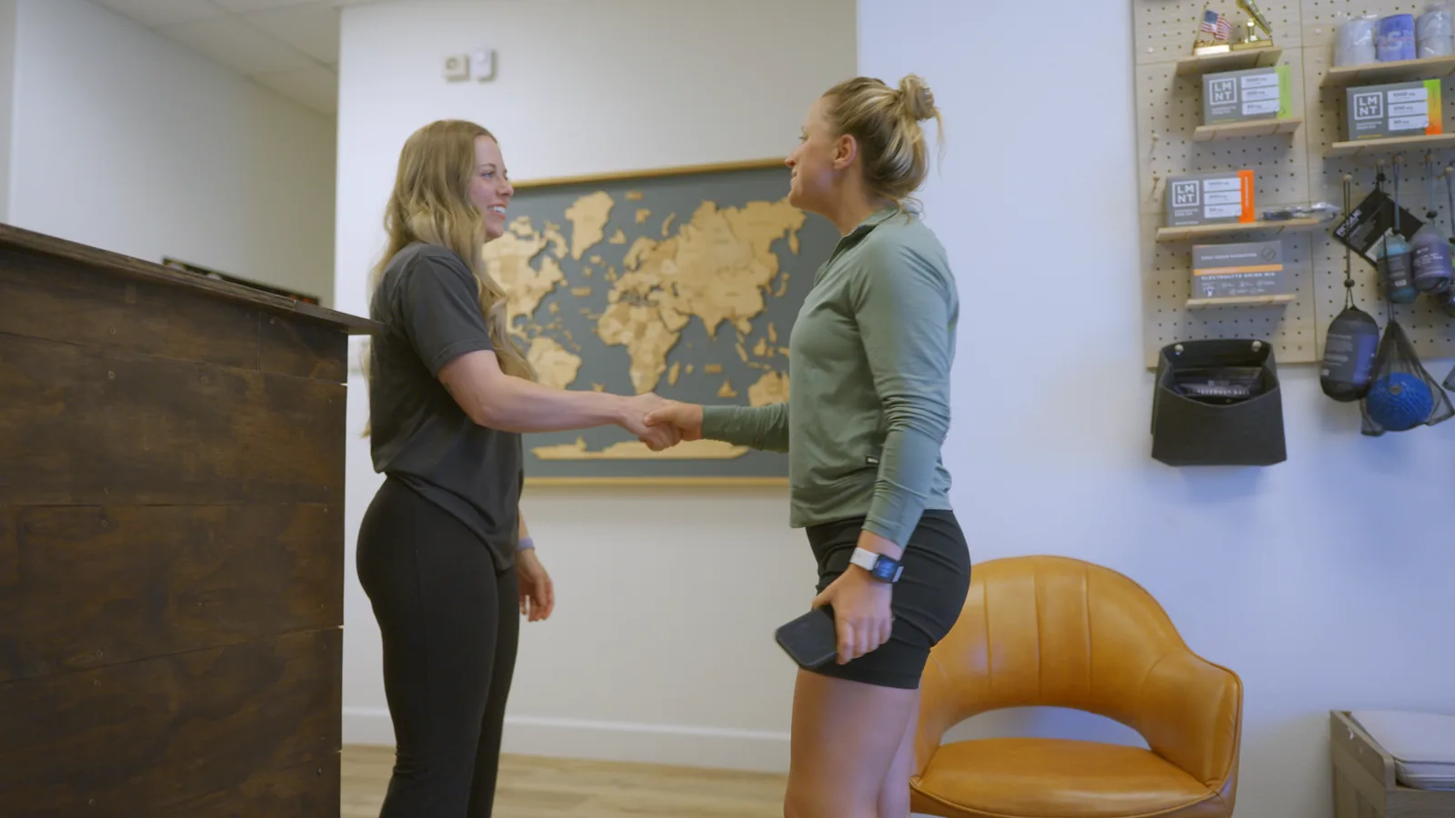 A physical therapist greeting a patient at the Pillar Kinetic front desk