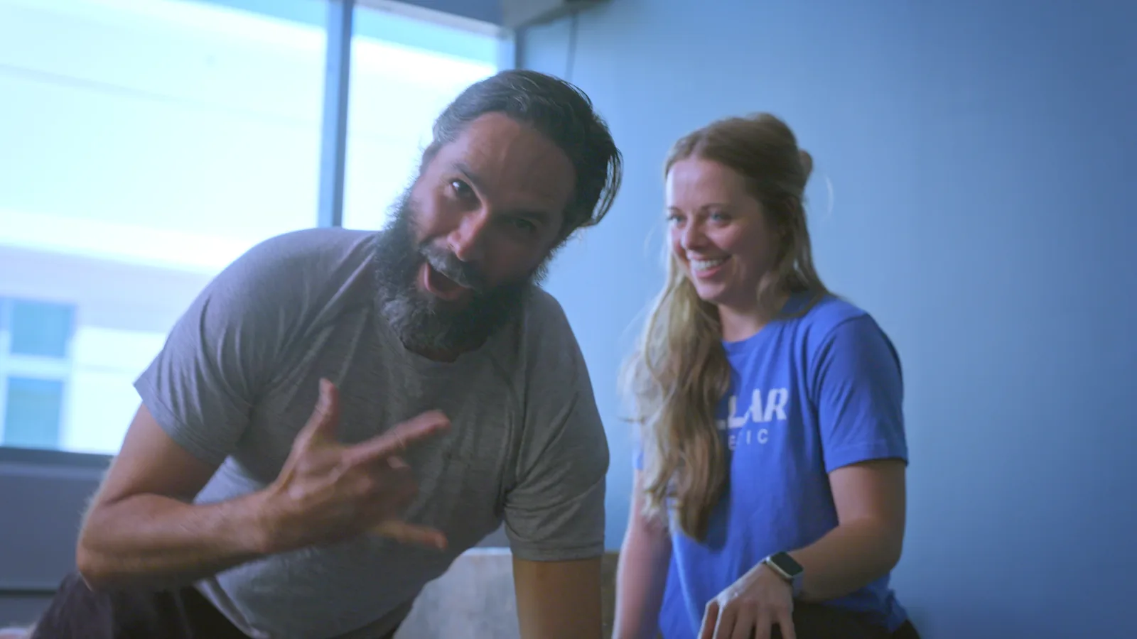 A physical therapist and a patient talking through an exercise in the clinic gym