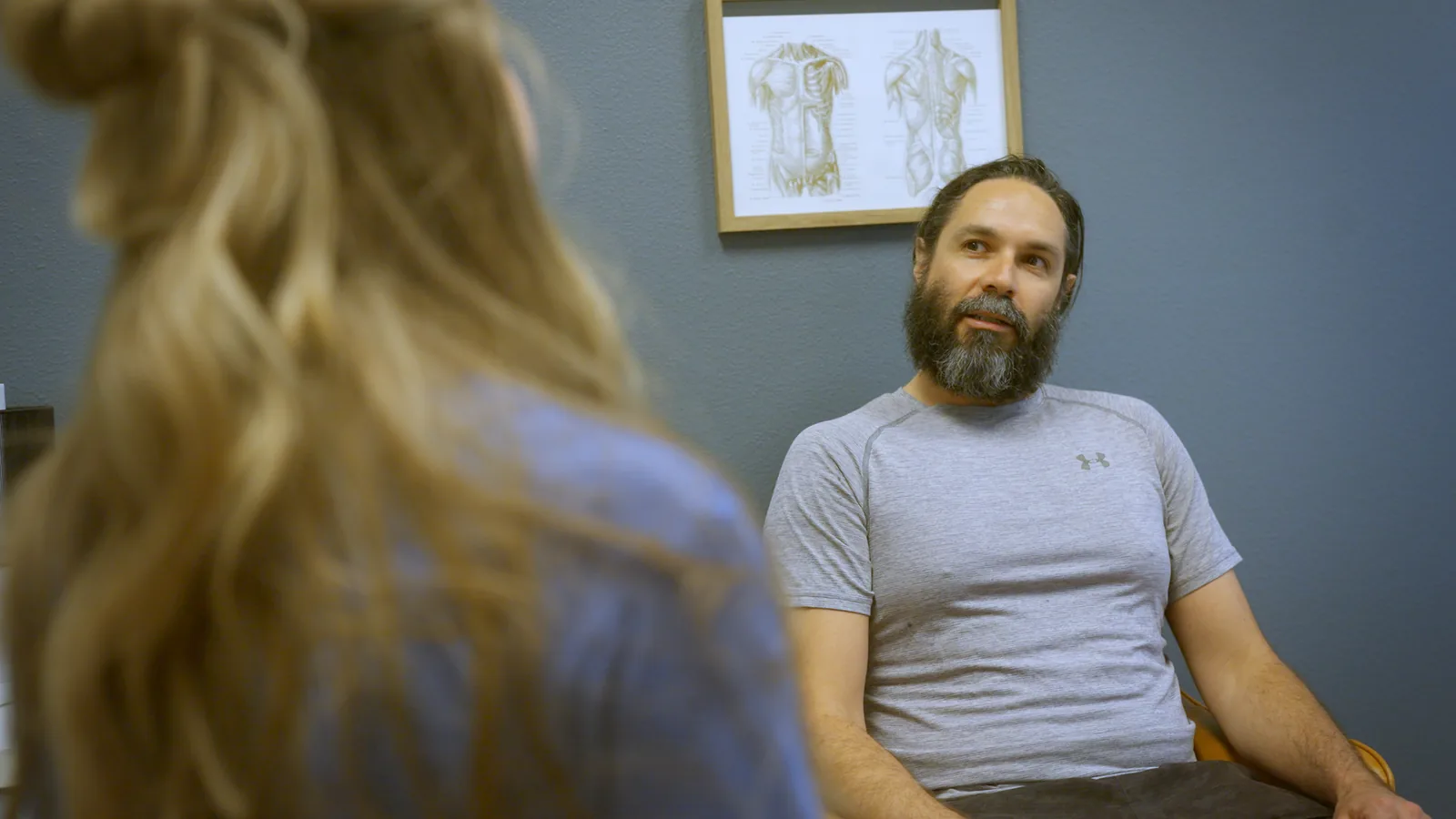 A man talking with his physical therapist in a consultation room