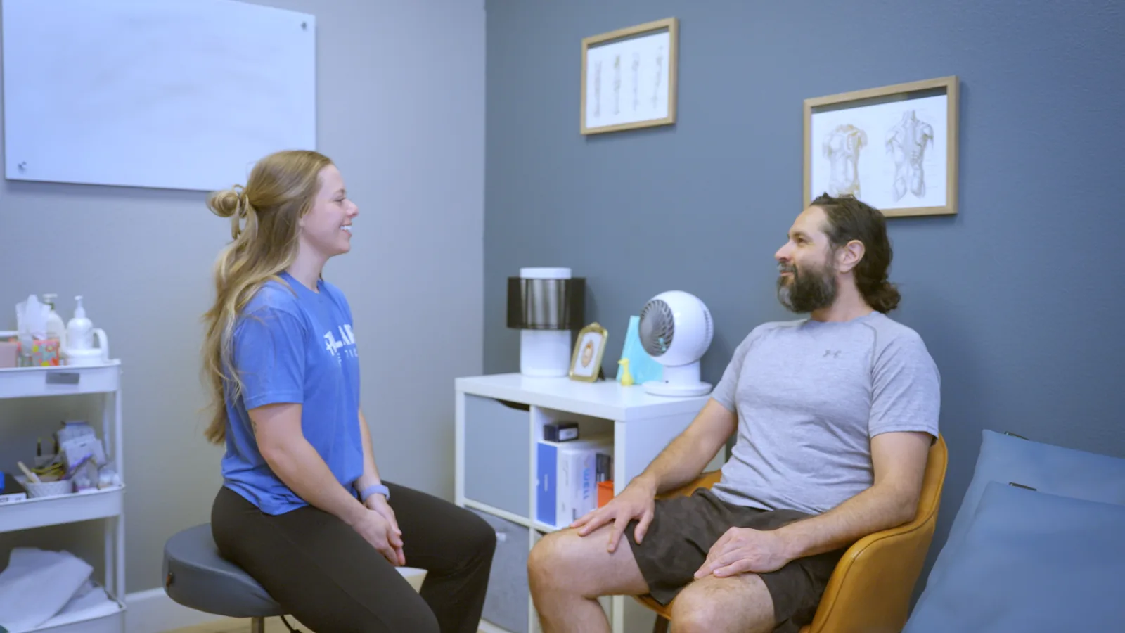 A physical therapist and a patient talking in a consultation room