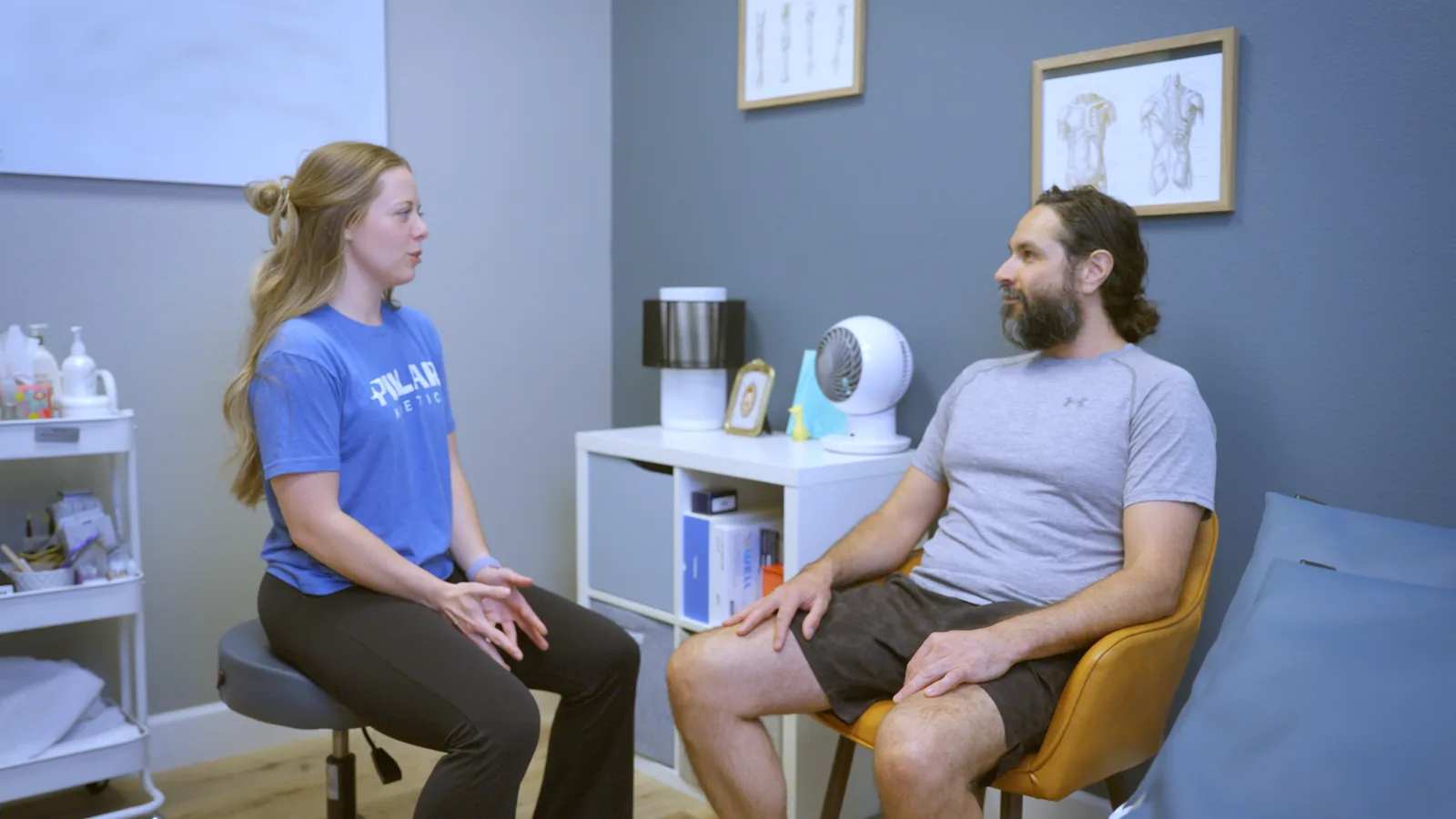 A man talking with his physical therapist in a private consultation room