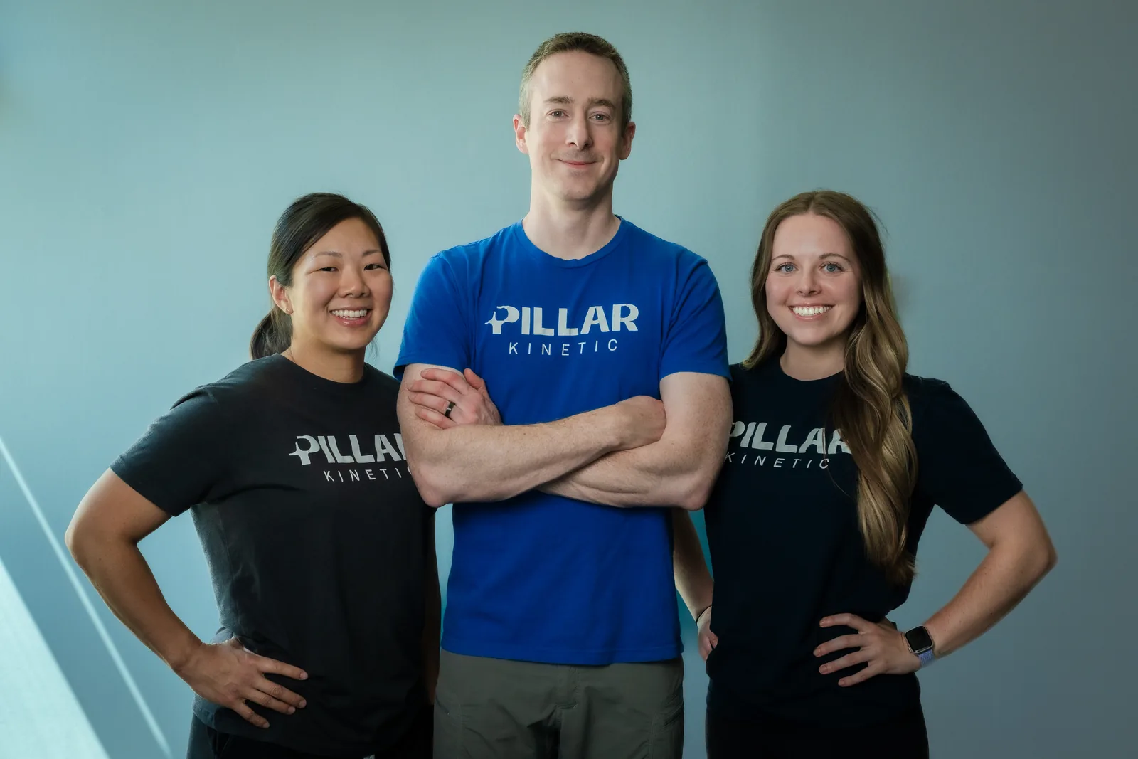 The clinic's three physical therapists standing together in Pillar Kinetic shirts
